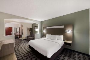a hotel room with a large bed and a bathroom at Quality Inn & Suites Irving DFW Airport South in Irving