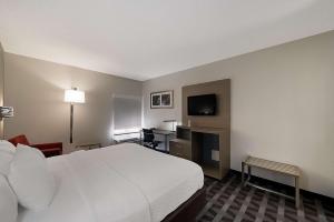 a hotel room with a bed and a television at Quality Inn & Suites Irving DFW Airport South in Irving