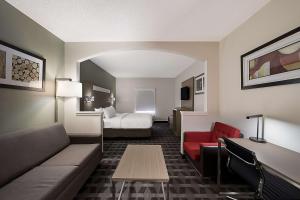 a hotel room with a couch and a bed at Quality Inn & Suites Irving DFW Airport South in Irving