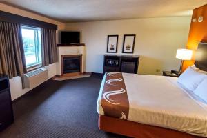 a hotel room with a bed and a fireplace at Quality Inn Atchison in Atchison