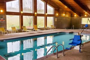 a swimming pool in a building with chairs and windows at Quality Inn Atchison in Atchison