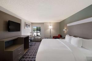 a hotel room with a large bed and a flat screen tv at Quality Inn & Suites Irving DFW Airport South in Irving