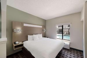 a hotel room with a large bed and a window at Quality Inn & Suites Irving DFW Airport South in Irving