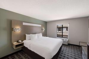 a hotel room with a large bed and a window at Quality Inn & Suites Irving DFW Airport South in Irving