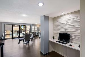 a dining room with a table and a computer on a counter at Quality Inn & Suites Irving DFW Airport South in Irving