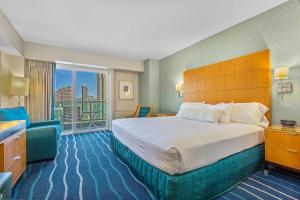 a hotel room with a bed and a balcony at CASTLE at Ala Moana Hotel in Honolulu