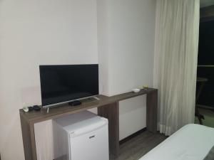 a television on a wooden table in a room at Via Premiere Suíte 409 B in Rio de Janeiro