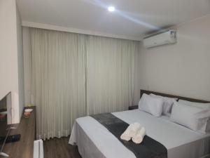 a bedroom with a bed with two towels on it at Via Premiere Suíte 409 B in Rio de Janeiro