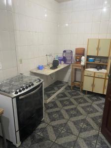 a kitchen with a stove and a tiled floor at Pousada Gama in Diamantina