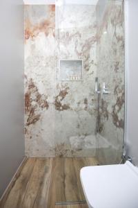 a bathroom with a shower and a toilet in it at Queen Apartmets Vlore in Vlorë +92 photos