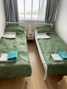 two twin beds in a room with a window at Newquay Fistral Beach View in Newquay