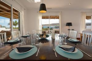a dining room with a table with blue plates and glasses at Villa Dedalos - Spacious luxury Villa with heated pool in Puerto Calero in Puerto Calero