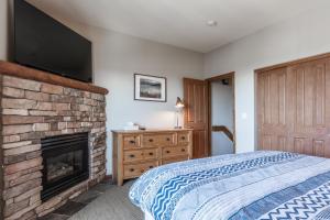 a bedroom with a fireplace and a flat screen tv at Eagle Run # 204 in Mammoth Lakes