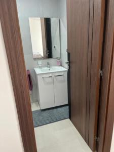 La salle de bains est pourvue d'un lavabo et d'un miroir. dans l'établissement شقة مفروشة بالمسبح و نادي رياضي, à Kenitra