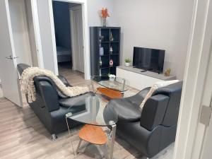 a living room with two chairs and a television at Cozy basement suite in Calgary