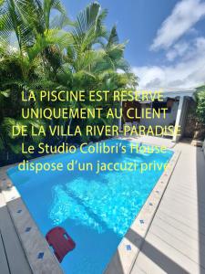een bord voor een villa met zwembad bij RIVER PARADISE in Goyave