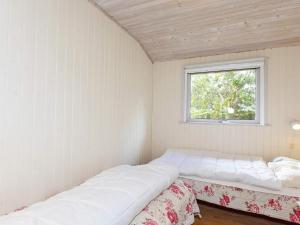 two beds in a small room with a window at 4 person holiday home in Hurup Thy-By Traum in Sønder Ydby