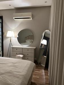 a bedroom with a bed and a dresser and a mirror at شقه مودرن in Riyadh