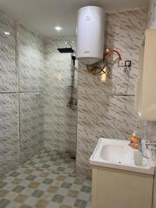 ein Bad mit einem Waschbecken und einer Lampe an der Wand in der Unterkunft Villa OMARI Situé à Saly Portudal Villa 2 Chambres bien équipés proche de tout in Saly Portudal + 21 Fotos