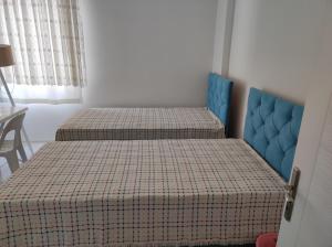 a bedroom with two beds and a blue headboard at Elif home in Kas