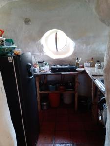 a kitchen with a black refrigerator and a window at Casa Ecológica Madre Tierra in Curití