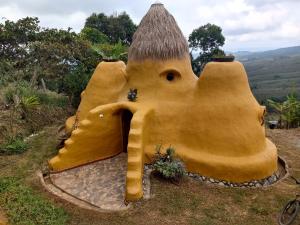 a large yellow play house in the grass at Casa Ecológica Madre Tierra in Curití