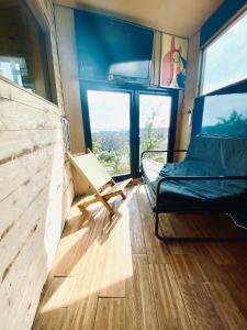 a room with a couch and a chair in a room with windows at Two Top Central Unique Artisan Beach Studios - also separate spa cabin in Brighton & Hove