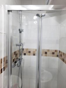 La salle de bains est pourvue d'une douche avec une porte en verre. dans l'établissement 47R Place, à Dagenham