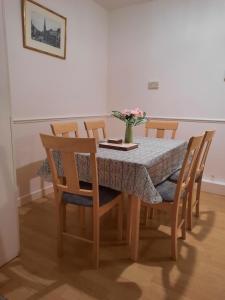 una mesa de comedor con un jarrón de flores. en 47R Place, en Dagenham