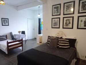 a bedroom with two beds and pictures on the wall at Pousada do Sossego Conceição de Jacareí in Mangaratiba