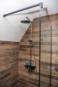 een douche met een douchekop in de badkamer bij Highlander guesthouse in Žabljak