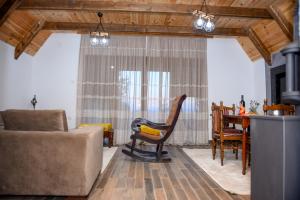 een woonkamer met een bank, een stoel en een tafel bij Highlander guesthouse in Žabljak