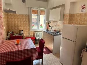a kitchen with a table and a white refrigerator at Venice Stefani Guesthouse in Marghera