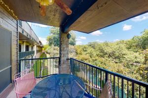 a balcony with a table and chairs on it at Camp Warnecke Estates Unit C204 in New Braunfels