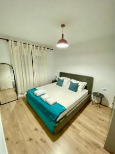 um quarto com uma cama grande e toalhas em Jolie Center Apartment em Tirana