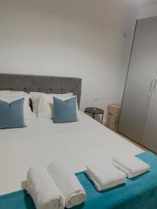 um quarto com uma cama branca com duas toalhas em Jolie Center Apartment em Tirana