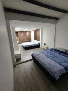 1 dormitorio con 1 cama grande y espejo en habitaciones disponibles en una casa en el norte de la ciudad, a 5 minutos del portal norte, en Bogotá