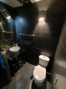 a bathroom with a white toilet and a sink at habitaciones disponibles en una casa en el norte de la ciudad, a 5 minutos del portal norte in Bogotá
