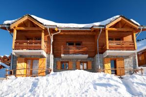 a log cabin in the snow with snow at Lagrange Vacances Le Grand Panorama II in Valmeinier