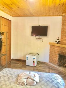 a room with a tv on the wall and a bed at Pousada Bella Ana in Visconde De Maua