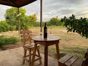 una mesa con una botella y dos copas de vino en Coccoloba Beach Hostel, en Dibulla