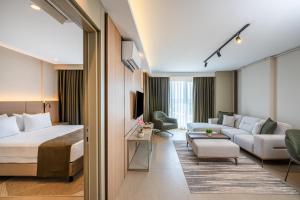 Habitación de hotel con cama y sala de estar. en Casamax Suites, en Antalya