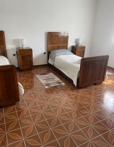 um quarto com 2 camas e piso em azulejo em Le ballerine em Crocetta