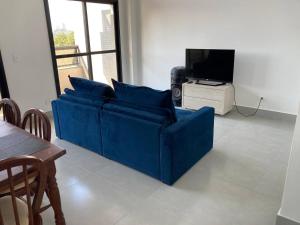 um sofá azul numa sala de estar com televisão em Sanches Tarsila em São José dos Campos