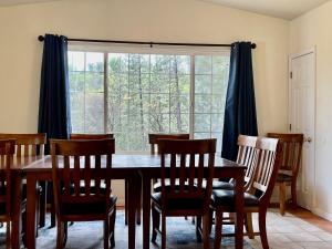 comedor con mesa, sillas y ventana en Bigfoot Suite Hot Tub Sleeps up to 4, en North Fork