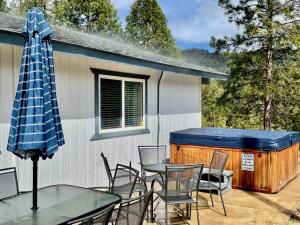patio con mesa, sillas y bañera de hidromasaje en Bigfoot Suite Hot Tub Sleeps up to 4, en North Fork