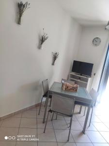 uma sala de jantar com mesa e cadeiras e uma televisão em Casa Joanna `San Salvo Marina` em Marina di Montenero