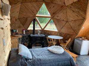 a room with a bed and a stove in a tent at Nomade Patagonia Glamping & Domos in Trevelin