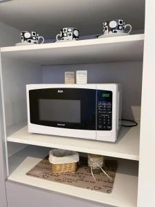 a white microwave on a shelf in a kitchen at Mendoza Your Apart in Mendoza