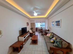 uma sala de estar com um sofá e uma mesa em Apartamento pé na areia e piscina em Capão da Canoa